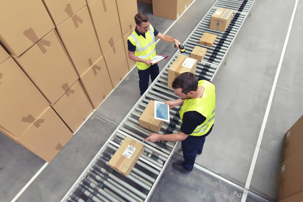 Two people working in warehouse checking stock