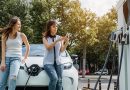 Two people using a phone to pay to use an EV charger.