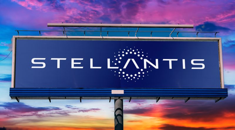 Image of the Stellantis logo on a large billboard with a multi-coloured sunset in the background to support Stellantis EV article