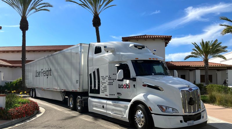 Image of a Uber Freight truck parked in a sunny car park in front of blue skies and palm trees to support Uber Freight article