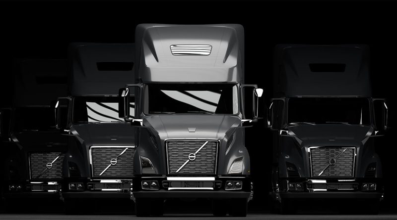 Image of multiple new Volvo VNL trucks lined up in a row in front of a black background