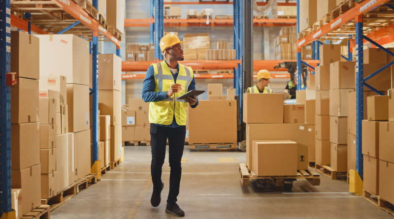 Warehouse workers manage inventory, representing third-party logistics (3PL) operations and supply chain efficiency.