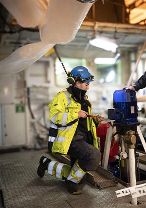 a professional industrial environment, wearing full personal protective equipment