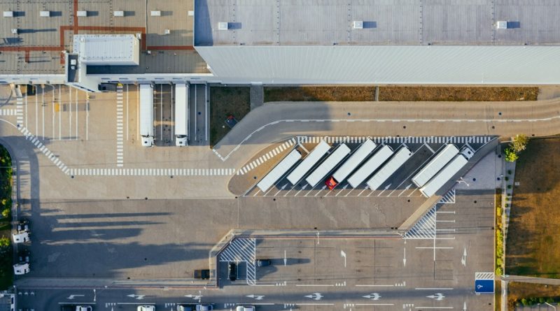 Aerial view of a 3PL warehouse and distribution centre with trucks parked at loading bays.