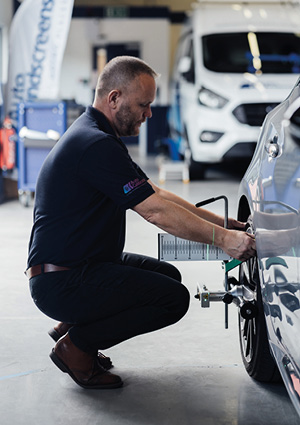 a mechanic performing a car wheel alignment