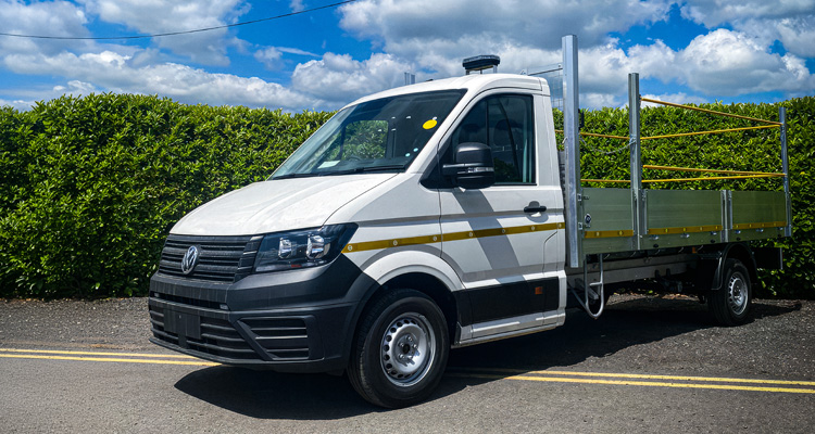 a white Volkswagen Crafter dropside or flatbed truck