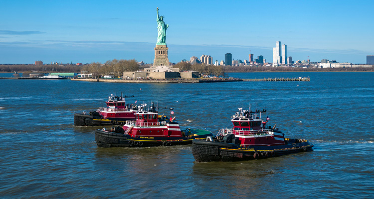 three McAllister Towing tugboats sailing in New York Harbor