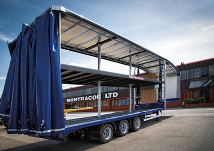 a Montracon double-deck curtainsider semi-trailer with a blue curtain pulled back
