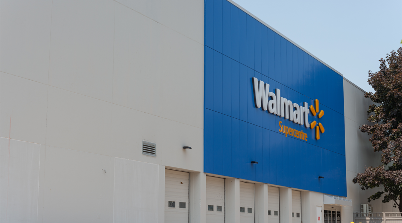 The blue and yellow Walmart logos on a large, modern grey commercial building