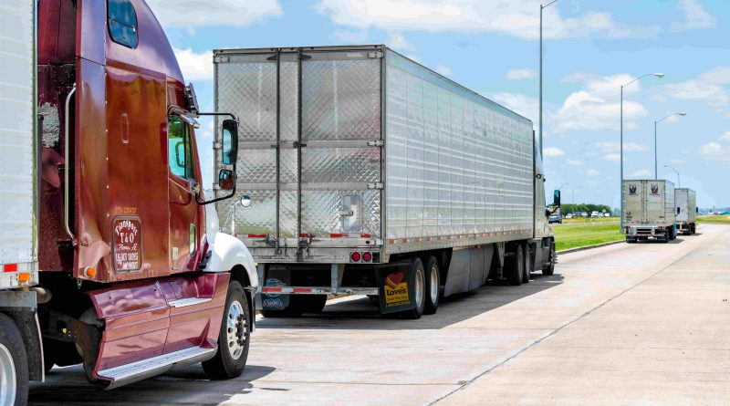 Semi trucks hauling freight trailers along a busy interstate highway