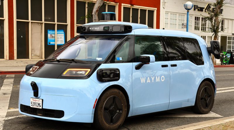 Autonomous robotaxi waiting at an airport terminal pickup zone
